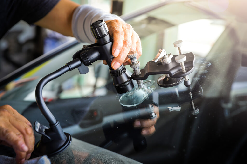 The broken car glass being repaired using professional equipment